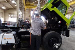Renew Truck technician checking yard truck components during routine maintenance. Concept image of “Proper Care of Your Yard Truck in Spring and Summer.”