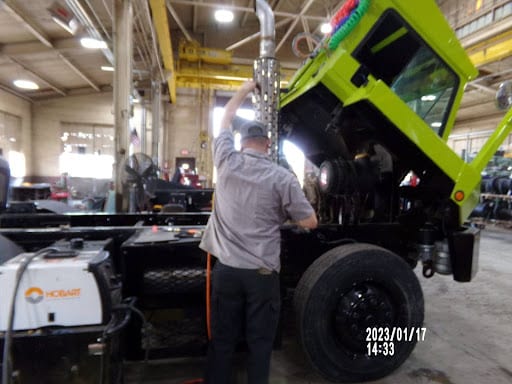 Effective Yard Truck Fleet Management | Renew Truck Tips. Image of mechanic performing maintenance services on yard truck in shop.