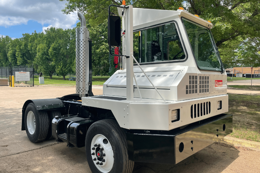 Kalmar Ottawa Yard Truck, spotter truck repair in New Boston, TX at Renew Truck. Kalmar terminal tractor parked outdoors, freshly serviced and ready for industrial use, showcasing its sturdy build and clean exterior against a tree-lined background.